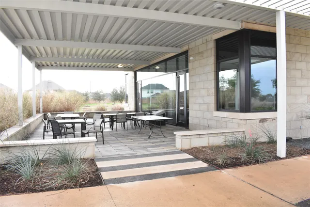 an outdoor space with lots of furniture and wooden floor