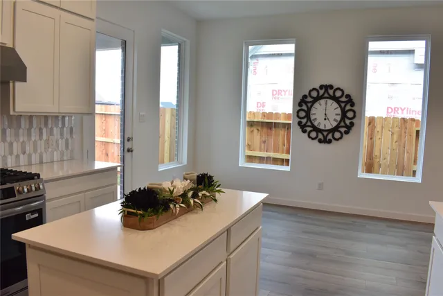 a kitchen with a table chairs a window and a stove