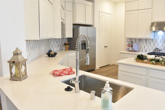 a kitchen with a sink refrigerator and cabinets