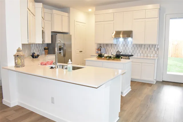 a kitchen with kitchen island a sink stove and refrigerator