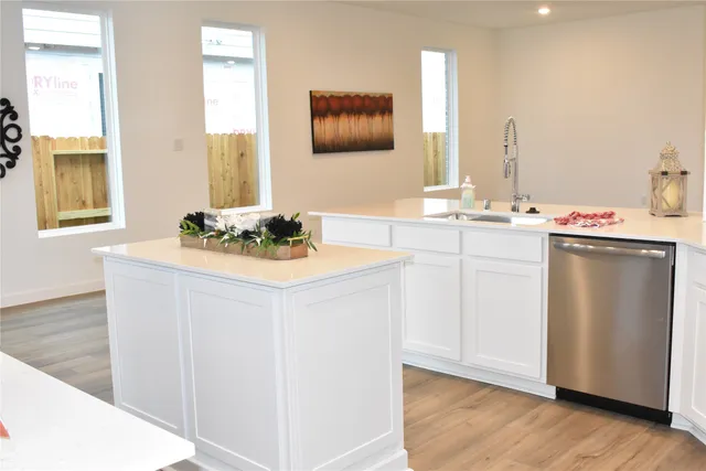 a kitchen with a sink cabinets and wooden floor