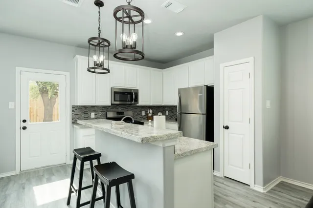 a kitchen with stainless steel appliances granite countertop a refrigerator and microwave