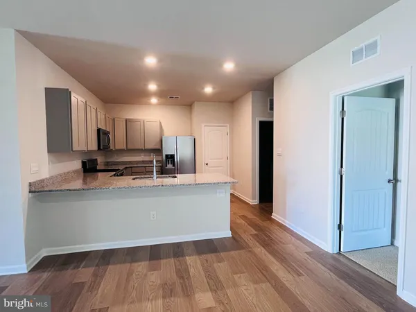a view of kitchen with stainless steel appliances granite countertop refrigerator oven a sink and dishwasher with wooden floor