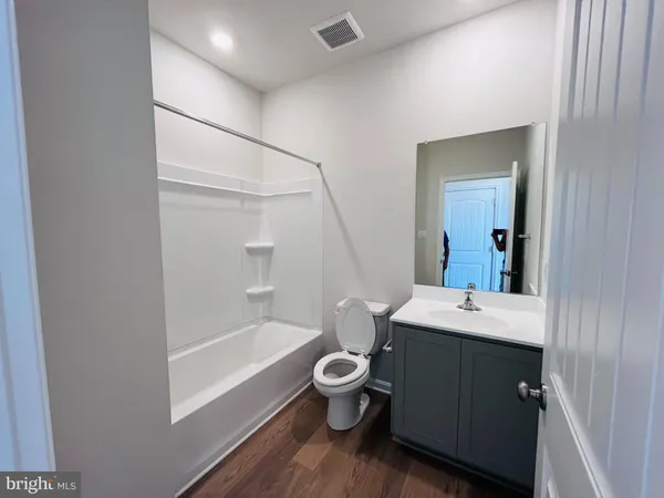 a bathroom with a sink a toilet a mirror and shower