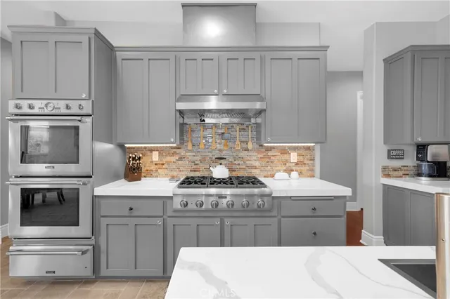 a kitchen with white cabinets and appliances