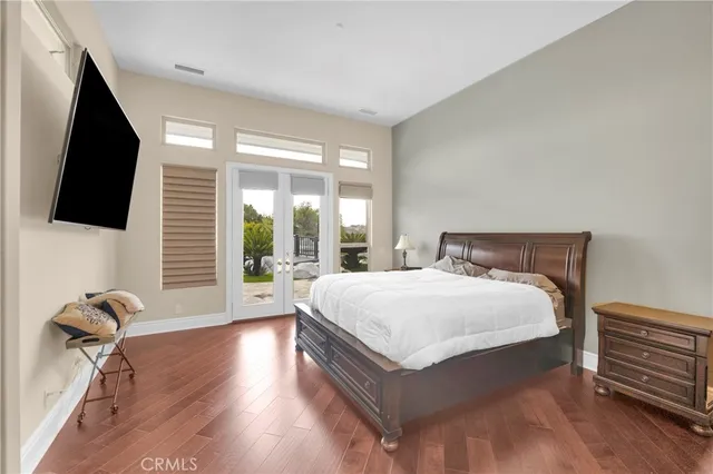 a bedroom with a bed and a flat tv screen on dresser