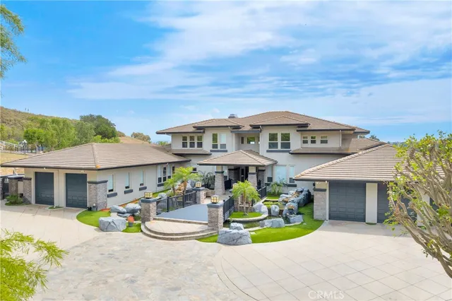 a view of a white house with a patio and a garden