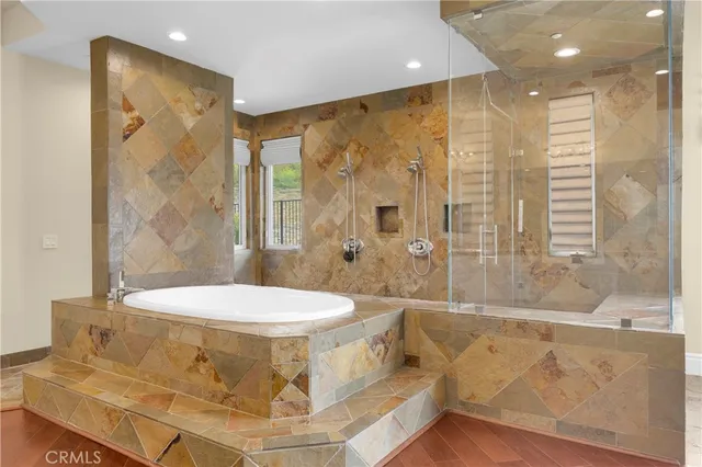 a bathroom with a large tub shower and sink