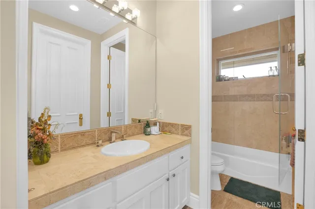 a bath tub sitting next to a white shower and vanity