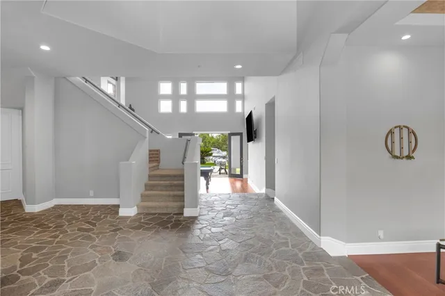 a room with furniture pool table flat screen tv and windows