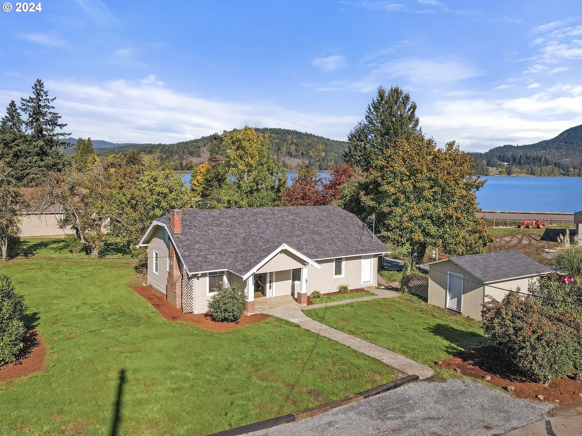an aerial view of residential houses with outdoor space and trees