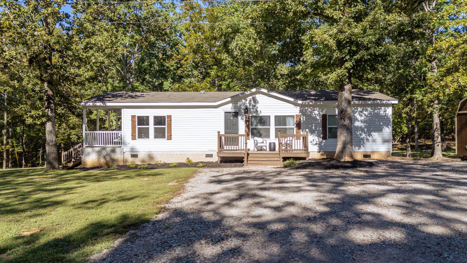 View of front of home with crawl space, a front lawn, and a deck