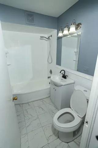 a white toilet sitting next to a bathroom sink