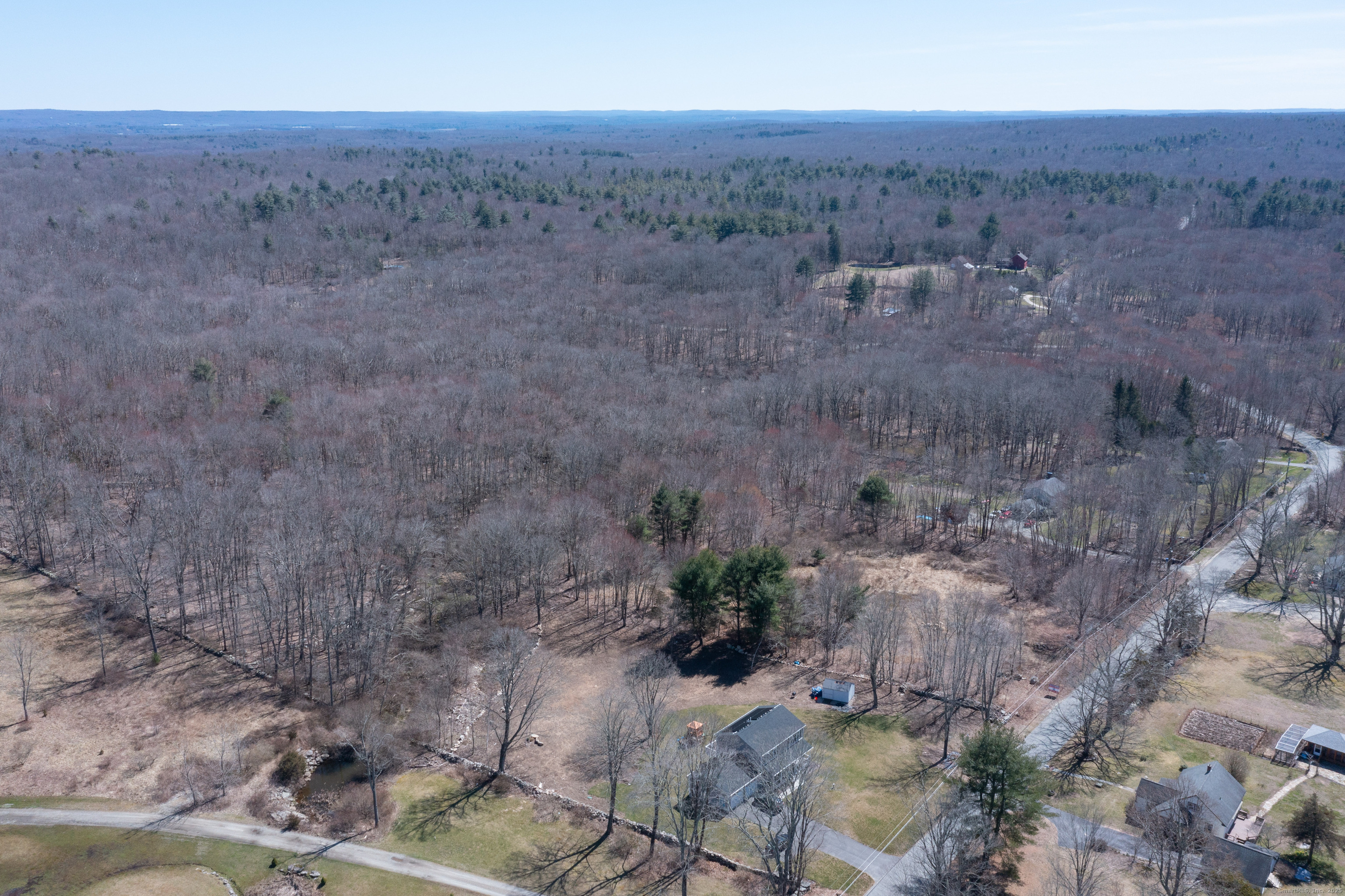 a view of a dry field with trees in the background