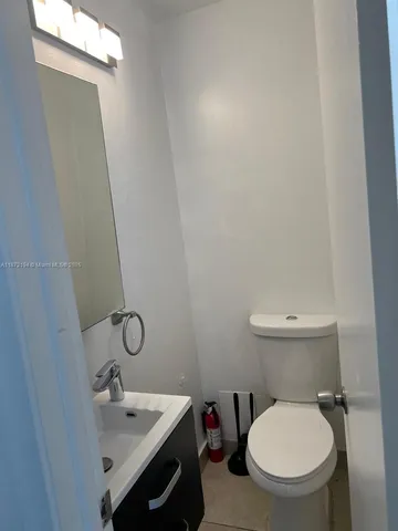 a bathroom with a toilet a sink and mirror