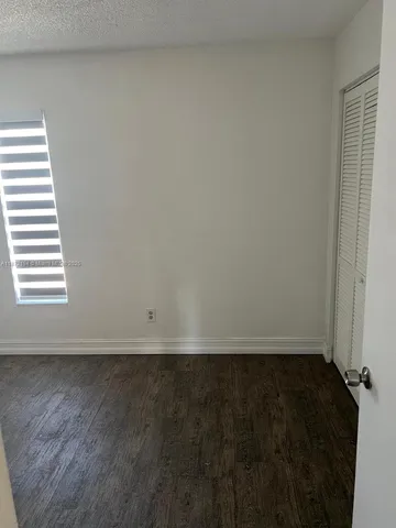 an empty room with wooden floor and a window