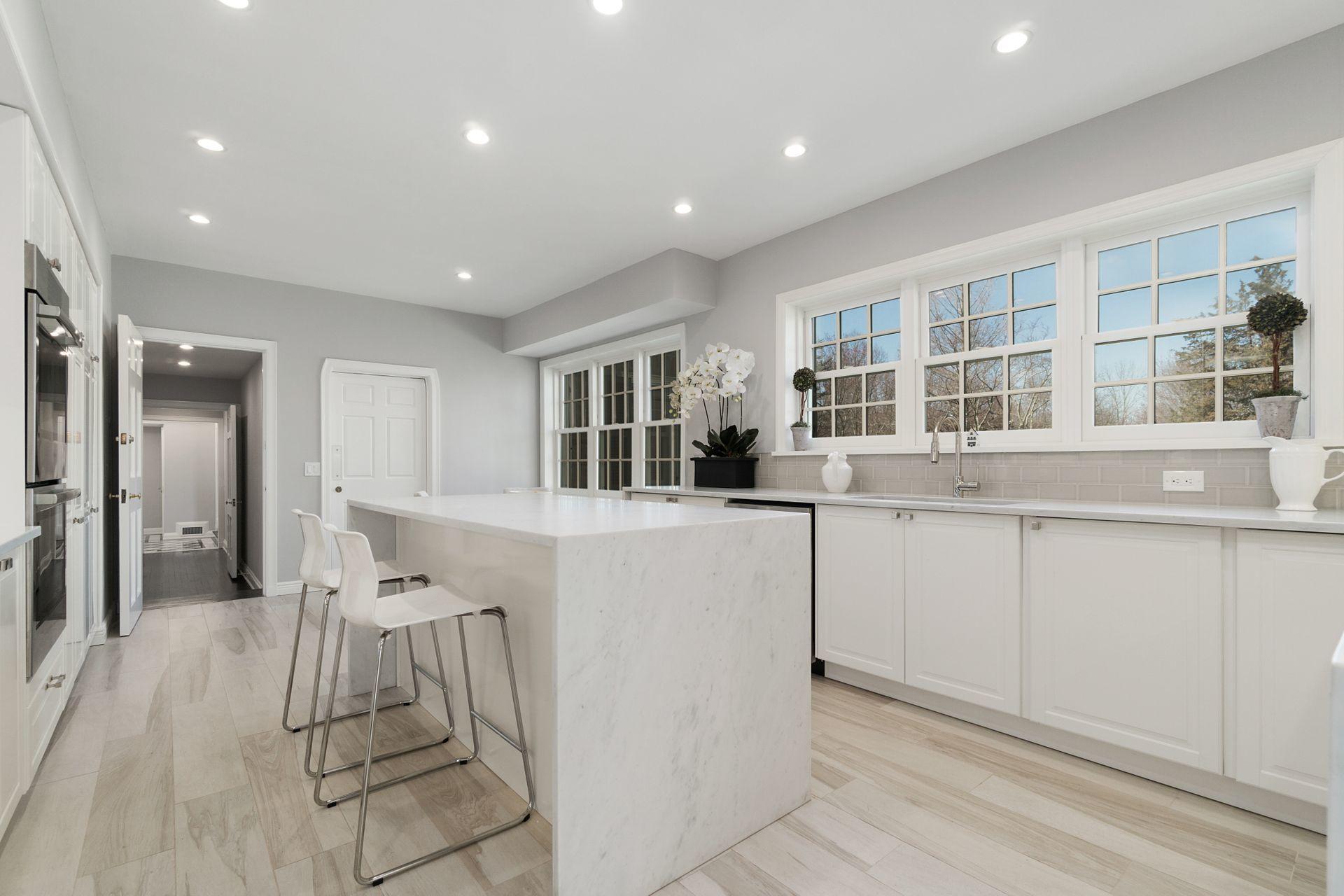 1102 Oenoke Ridge New Canaan, CT 06840 - Photo 17 of 49 a kitchen with white cabinets and chairs