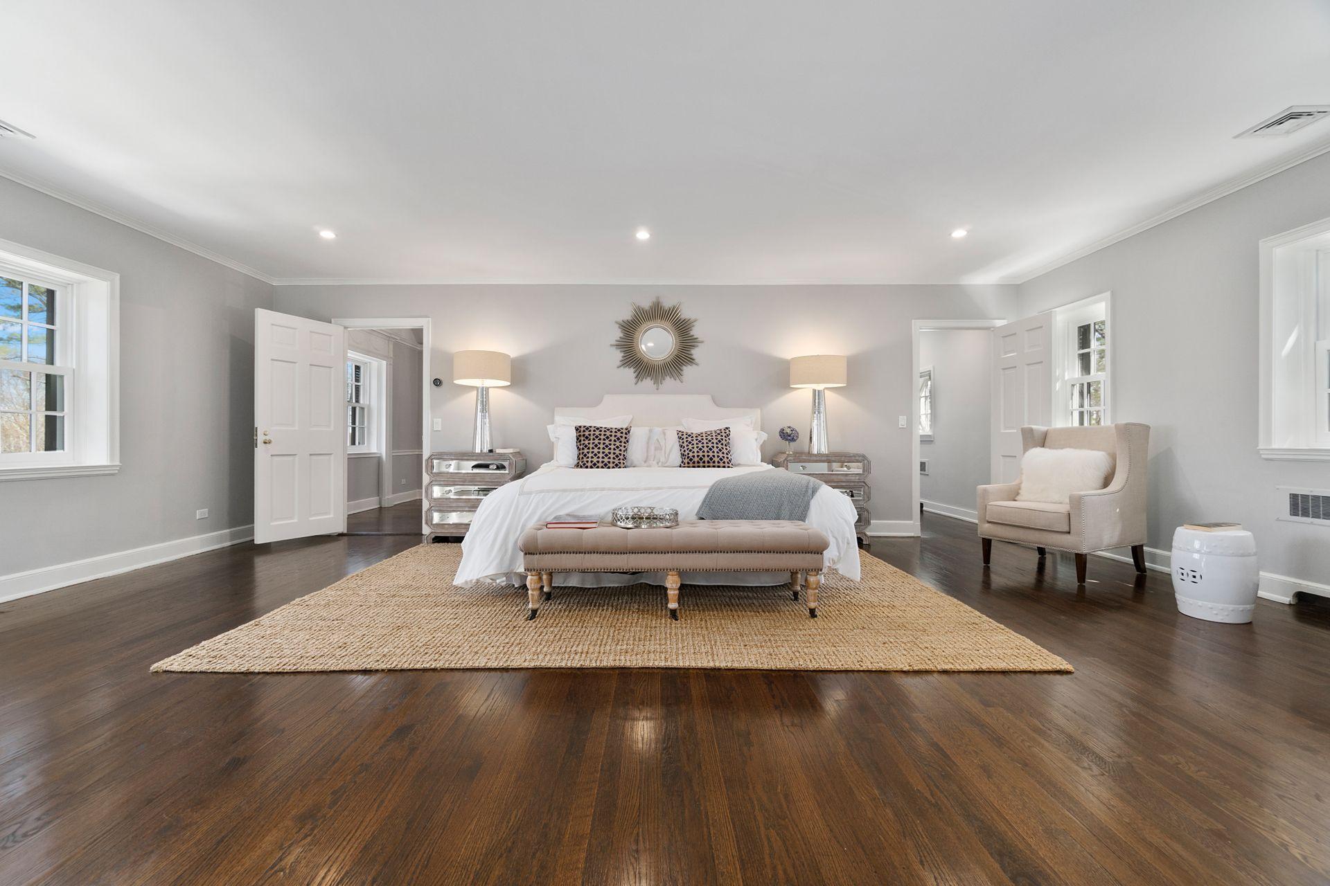 1102 Oenoke Ridge New Canaan, CT 06840 - Photo 22 of 49 a spacious bedroom with a bed a table and wooden floor
