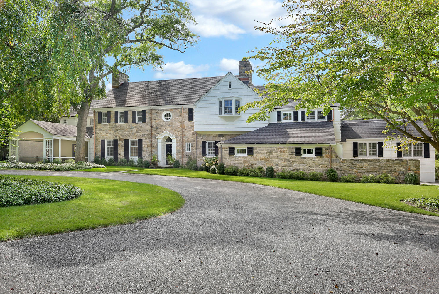 1102 Oenoke Ridge New Canaan, CT 06840 - Photo 8 of 49 a front view of a house with a garden and trees