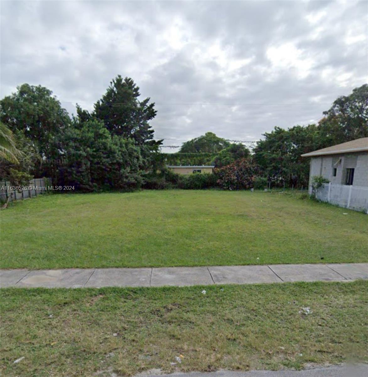 10210 Southwest 170th Terrace Miami, FL 33157 - Photo 1 of 2 a view of a green field with wooden fence