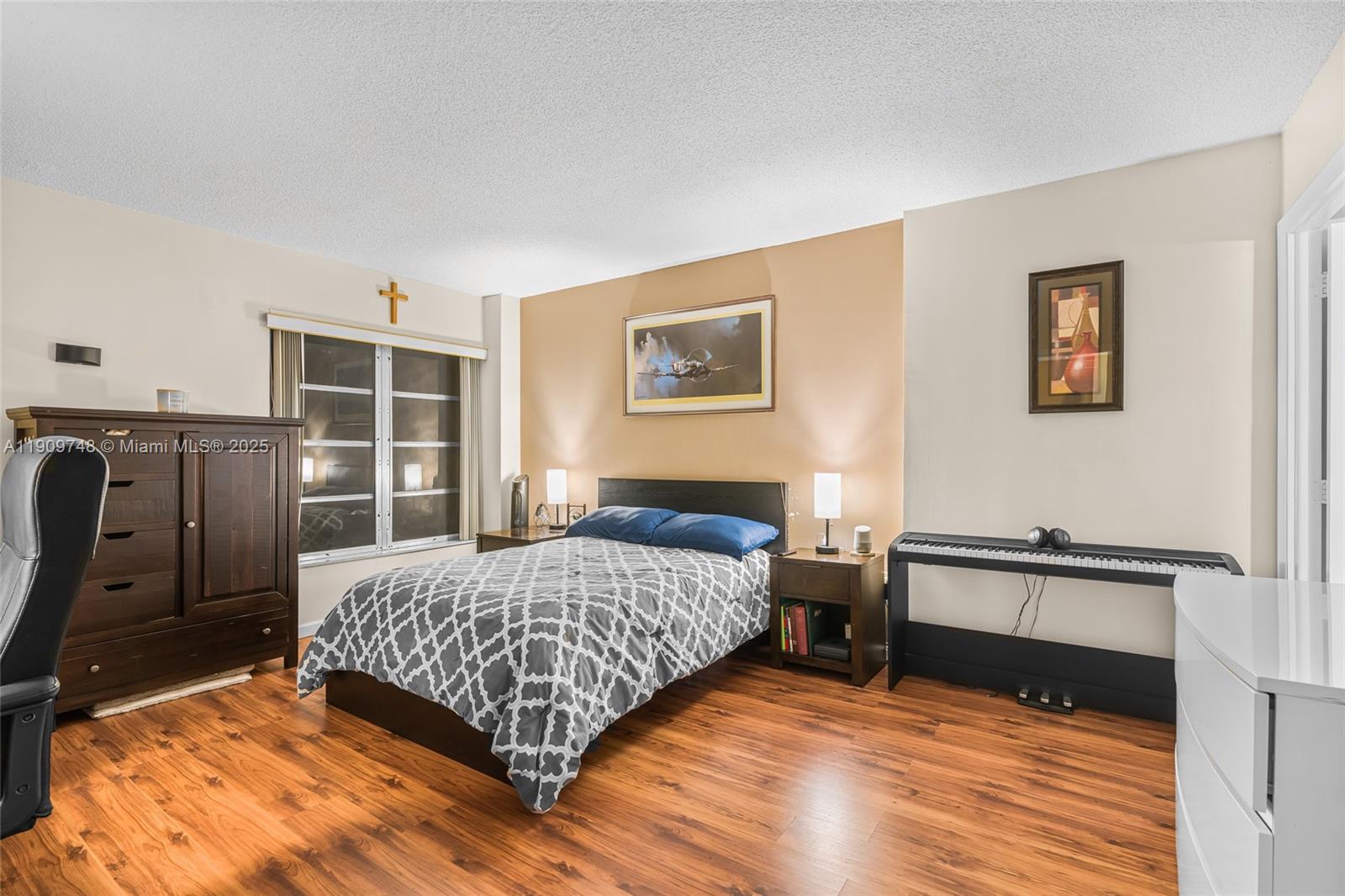 4166 Inverrary Drive, Unit 306 Lauderhill, FL 33319 - Photo 11 of 30 a bedroom with a bed and a dresser with wooden floor