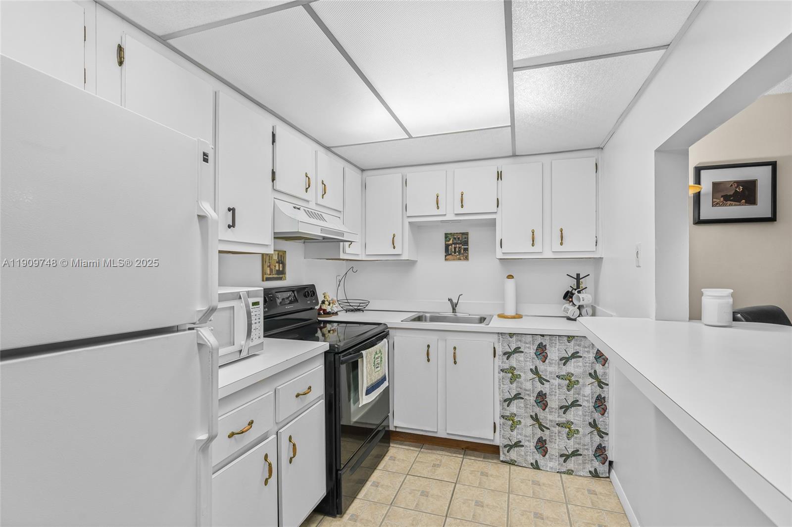 4166 Inverrary Drive, Unit 306 Lauderhill, FL 33319 - Photo 4 of 30 a kitchen with stainless steel appliances granite countertop a sink a stove a refrigerator and white cabinets