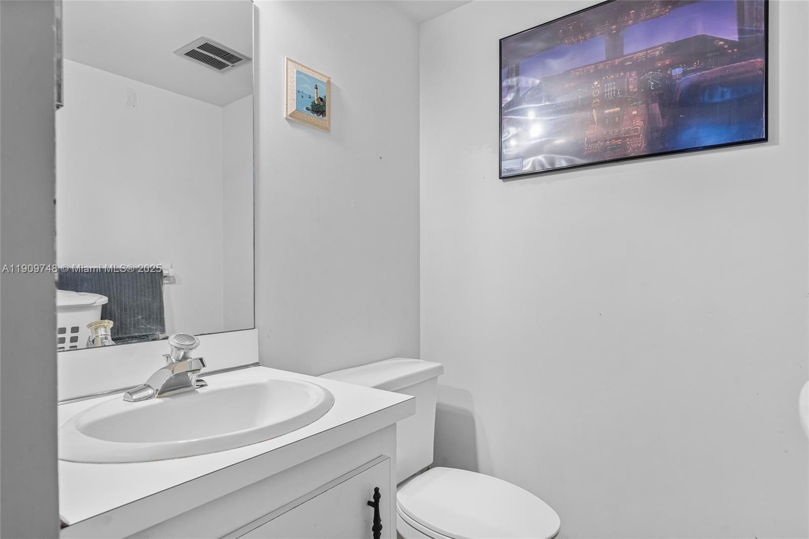 4166 Inverrary Drive, Unit 306 Lauderhill, FL 33319 - Photo 10 of 30 a bathroom with a toilet sink and mirror