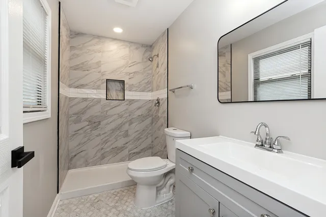 a bathroom with a toilet sink and mirror