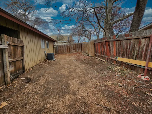 a view of backyard with wooden fence