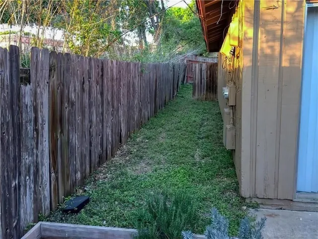 a view of a backyard with wooden fence