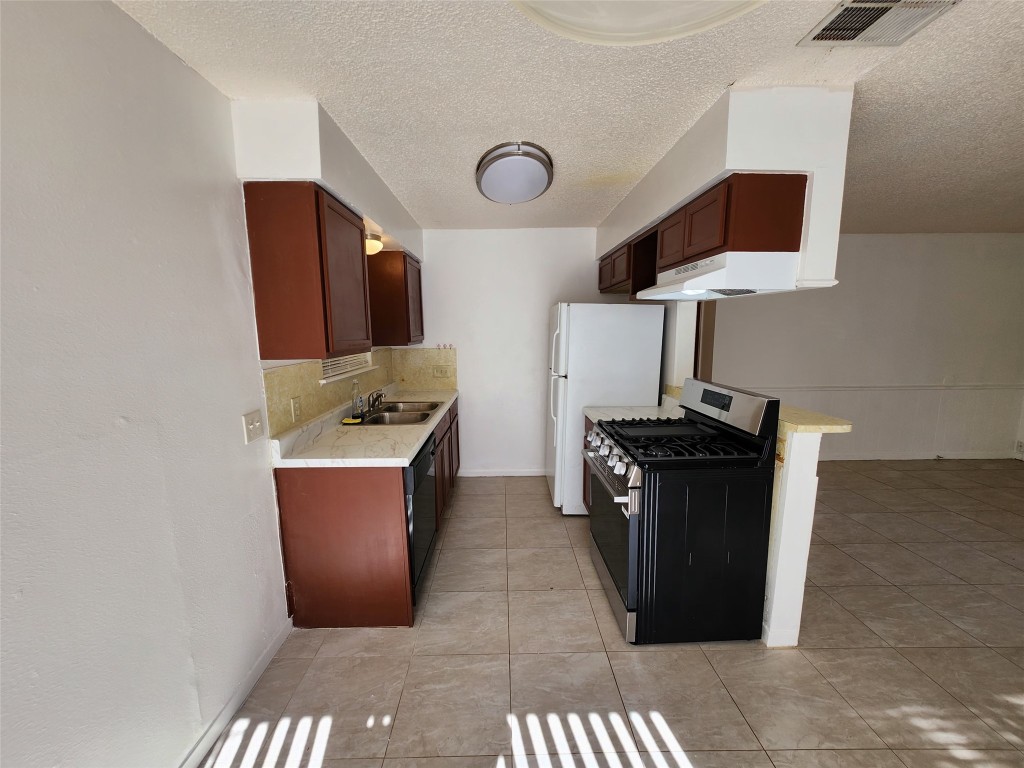 2404 Audubon Place, Unit B Austin, TX 78741 - Photo 10 of 23 a kitchen with stainless steel appliances granite countertop a sink and a stove