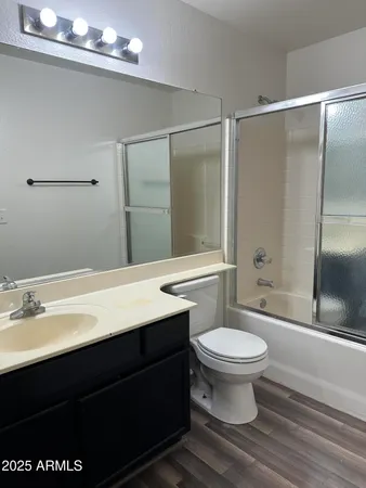 a bathroom with a sink a toilet a mirror and shower