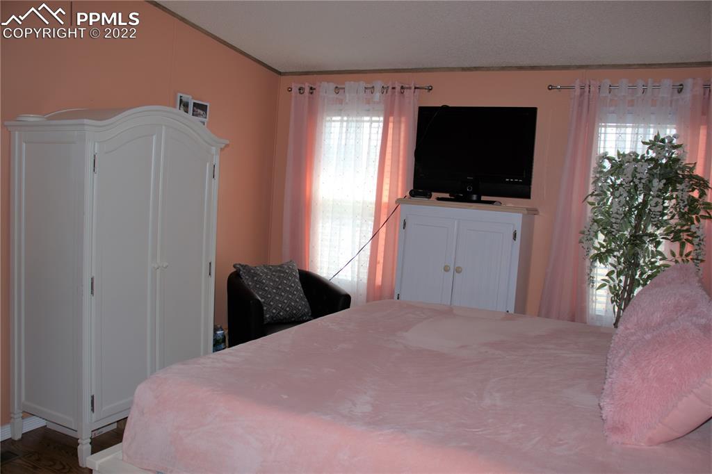 728 Graphite Street Florence, CO 81226 - Photo 11 of 30 a bedroom with a bed and a flat tv screen on dresser