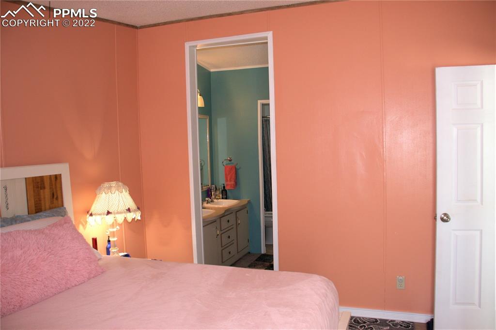 728 Graphite Street Florence, CO 81226 - Photo 10 of 30 a bedroom with a bed and a lamp on dresser