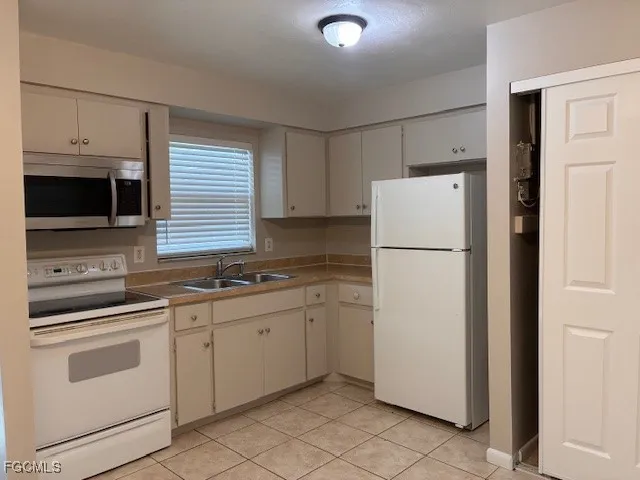 a kitchen with appliances a sink and cabinets