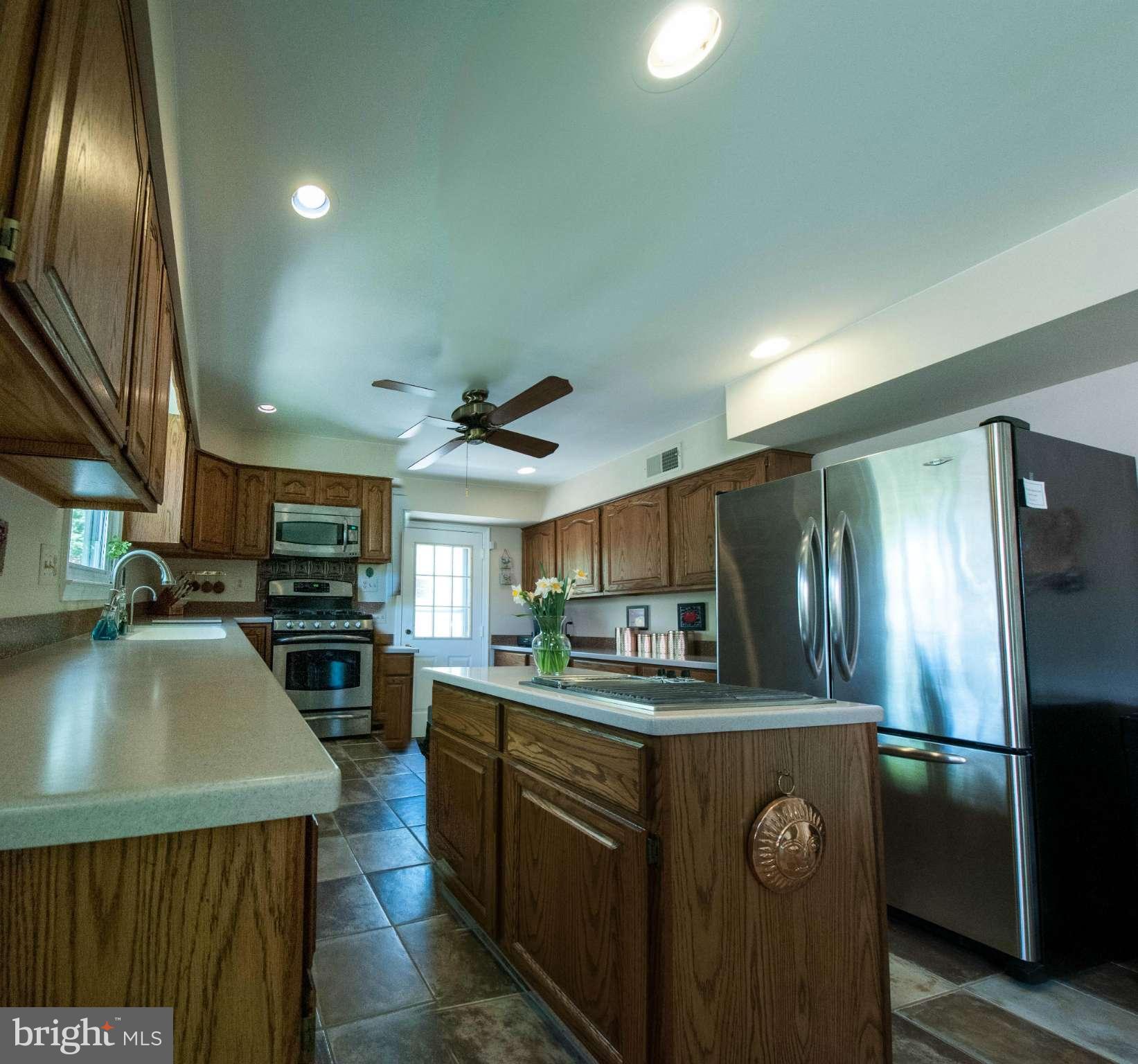 11662 Havenner Road Fairfax Station, VA 22039 - Photo 15 of 30 a kitchen with kitchen island granite countertop stainless steel appliances a sink stove top oven and refrigerator