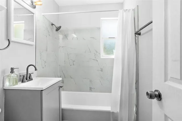 a bathroom with a bathtub a shower a sink and a mirror