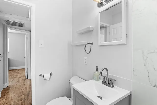 a bathroom with a sink mirror and toilet