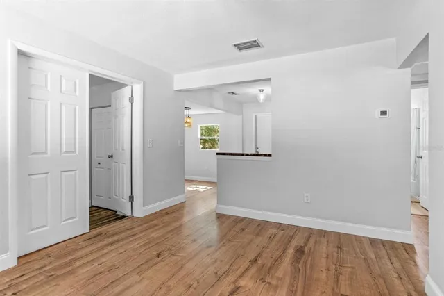 a view of empty room with wooden floor