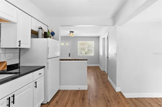 a kitchen with cabinets and wooden floor