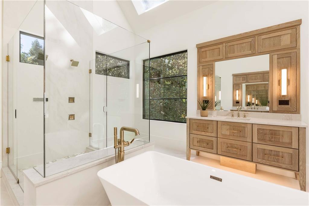 388 Londonberry Road Northwest Sandy Springs, GA 30327 - Photo 34 of 84 a bathroom with a tub a sink a mirror and a shower