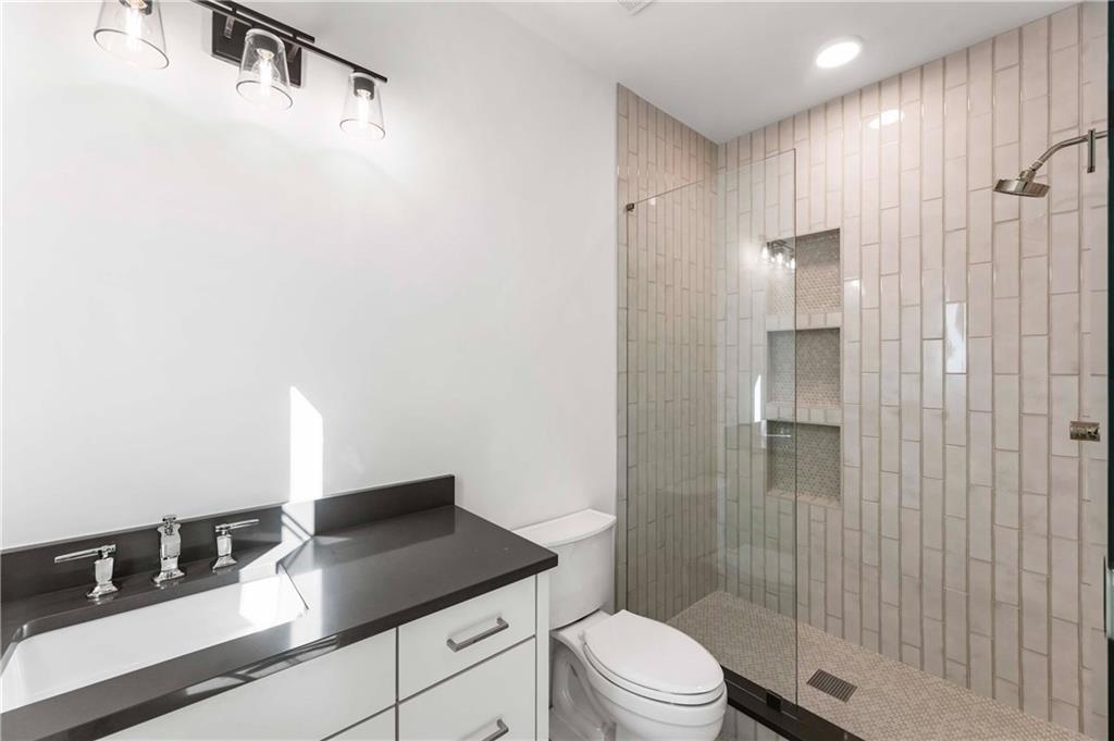 388 Londonberry Road Northwest Sandy Springs, GA 30327 - Photo 56 of 84 a bathroom with a granite countertop sink a toilet and shower