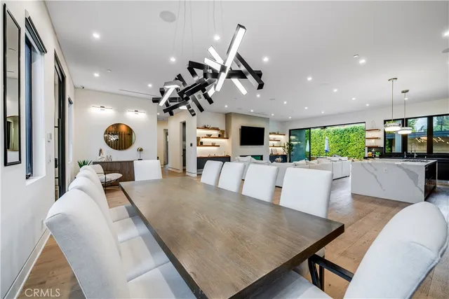 a living room with furniture kitchen view and a chandelier