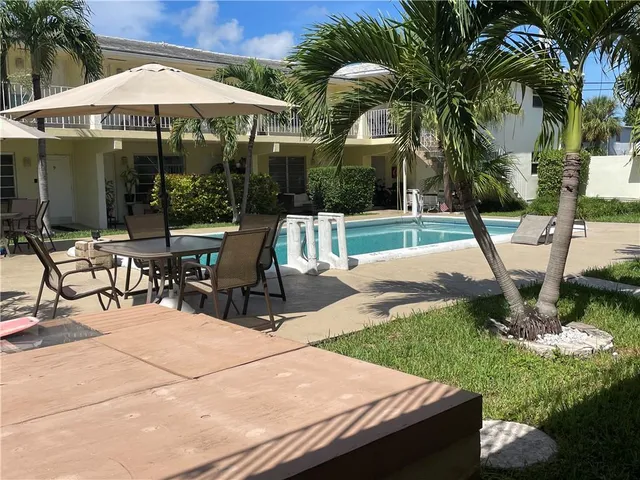 a view of a patio with table and chairs under an umbrella