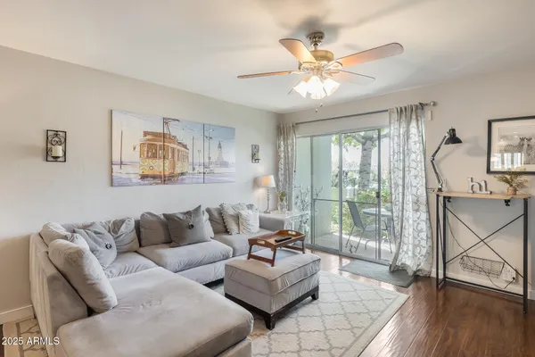 a living room with furniture and a large window with wooden floor