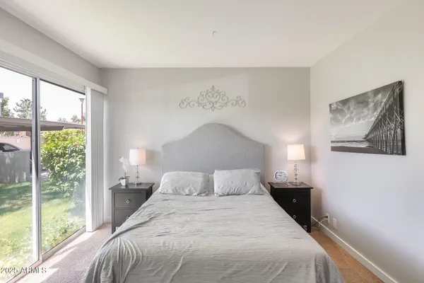 a bedroom with a bed and a painting on the wall