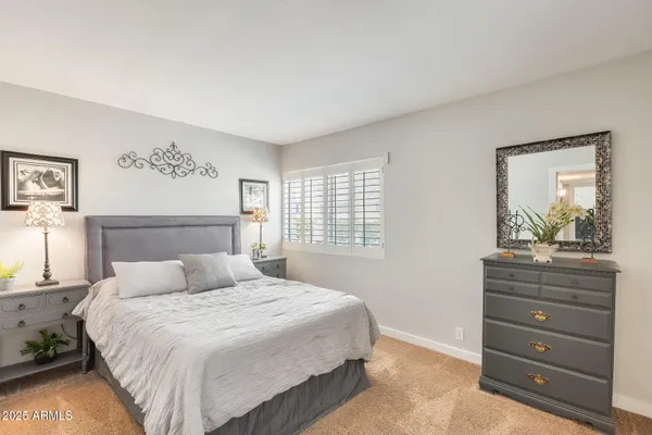 a bedroom with a bed and a mirror on dresser