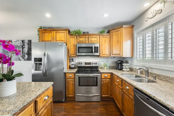 a kitchen with granite countertop a sink stainless steel appliances and counter space