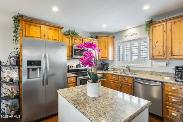 a kitchen with stainless steel appliances granite countertop a sink window and refrigerator