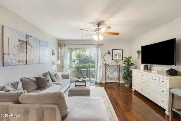 a living room with furniture a flat screen tv and a floor to ceiling window